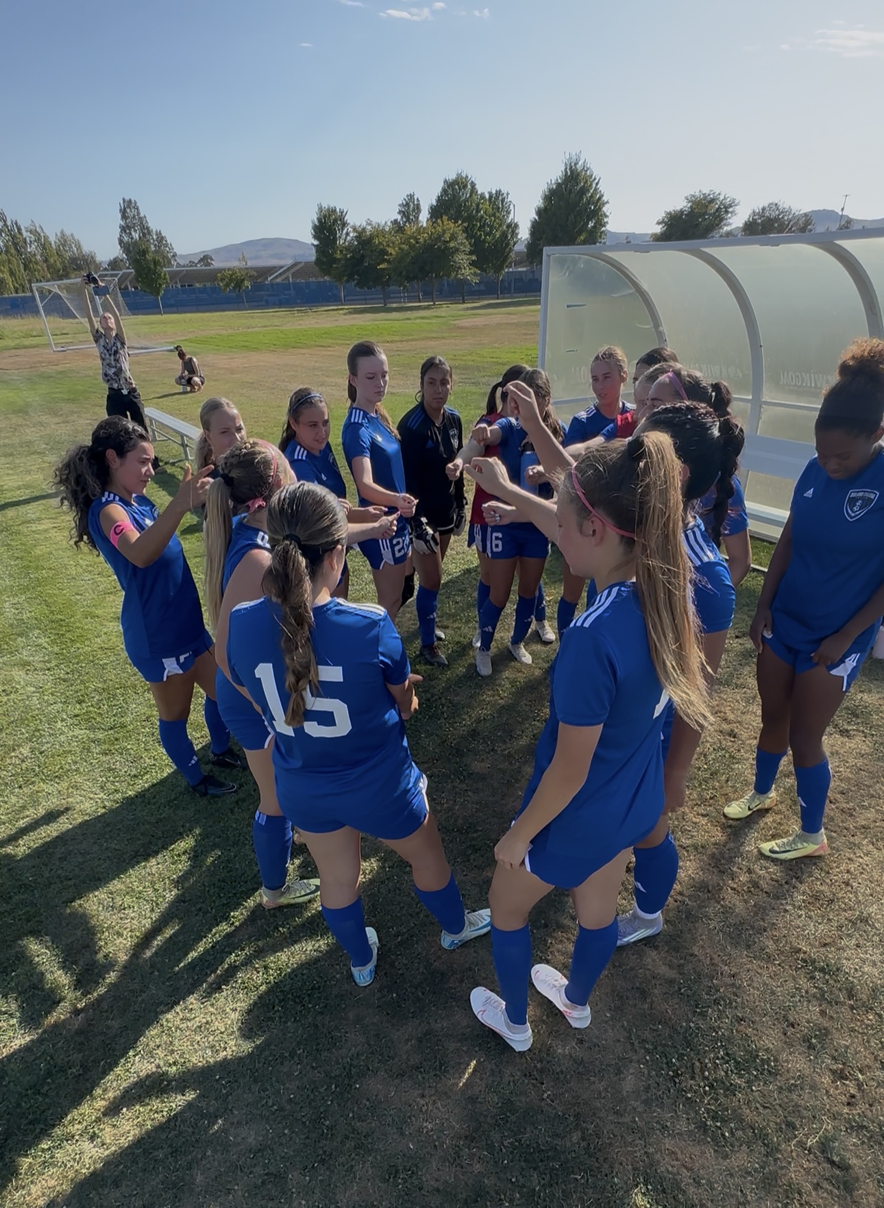 Women's soccer team huddle at halftime lead by Captains Kalina Osorio and Katelyn Walbolt
