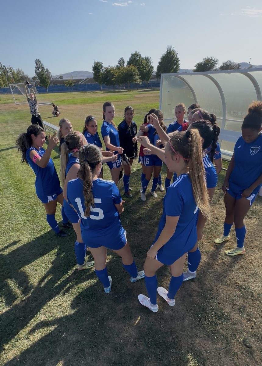 Women's soccer team huddle at halftime lead by Captains Kalina Osorio and Katelyn Walbolt
