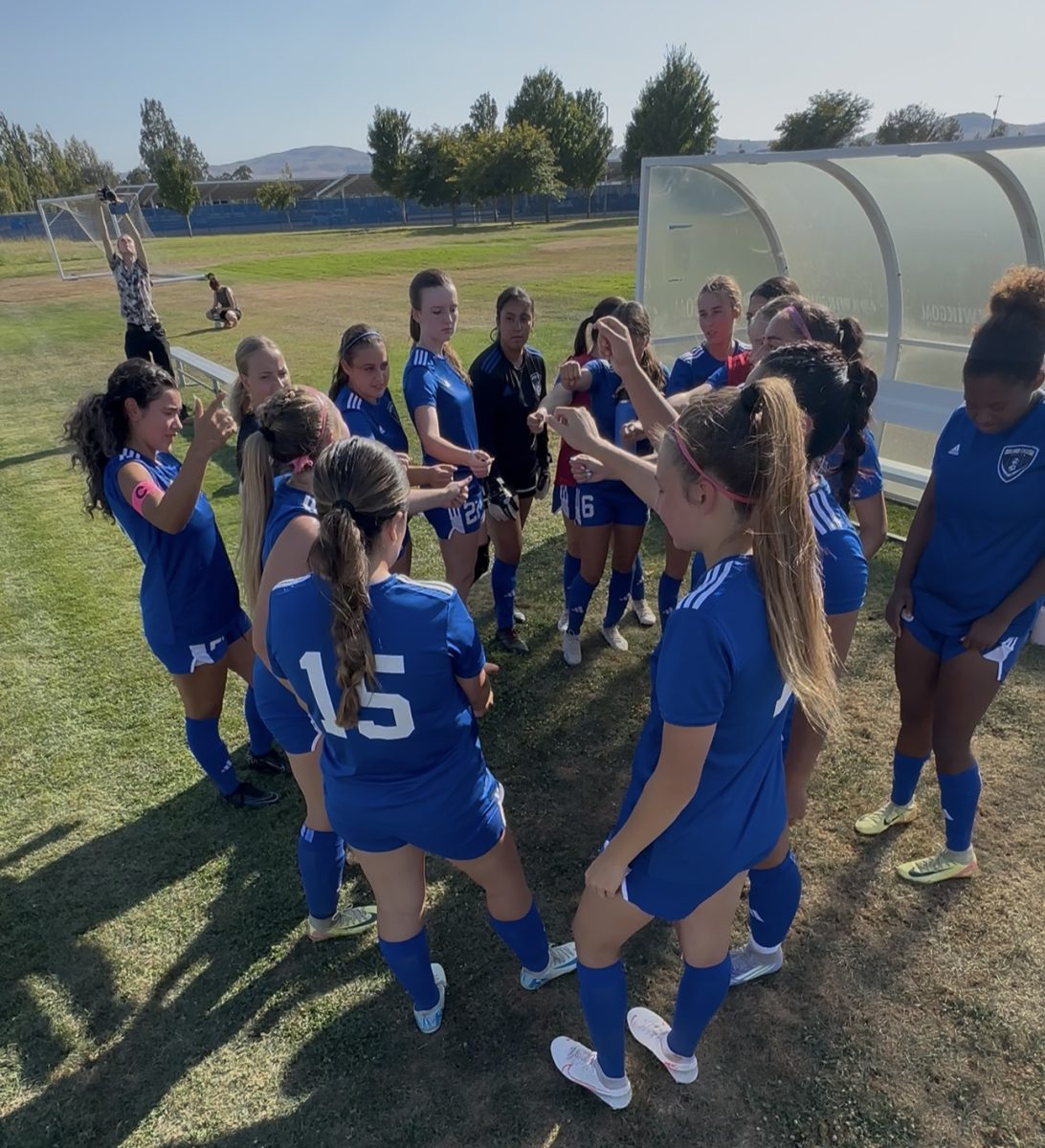 Women's soccer team huddle at halftime lead by Captains Kalina Osorio and Katelyn Walbolt